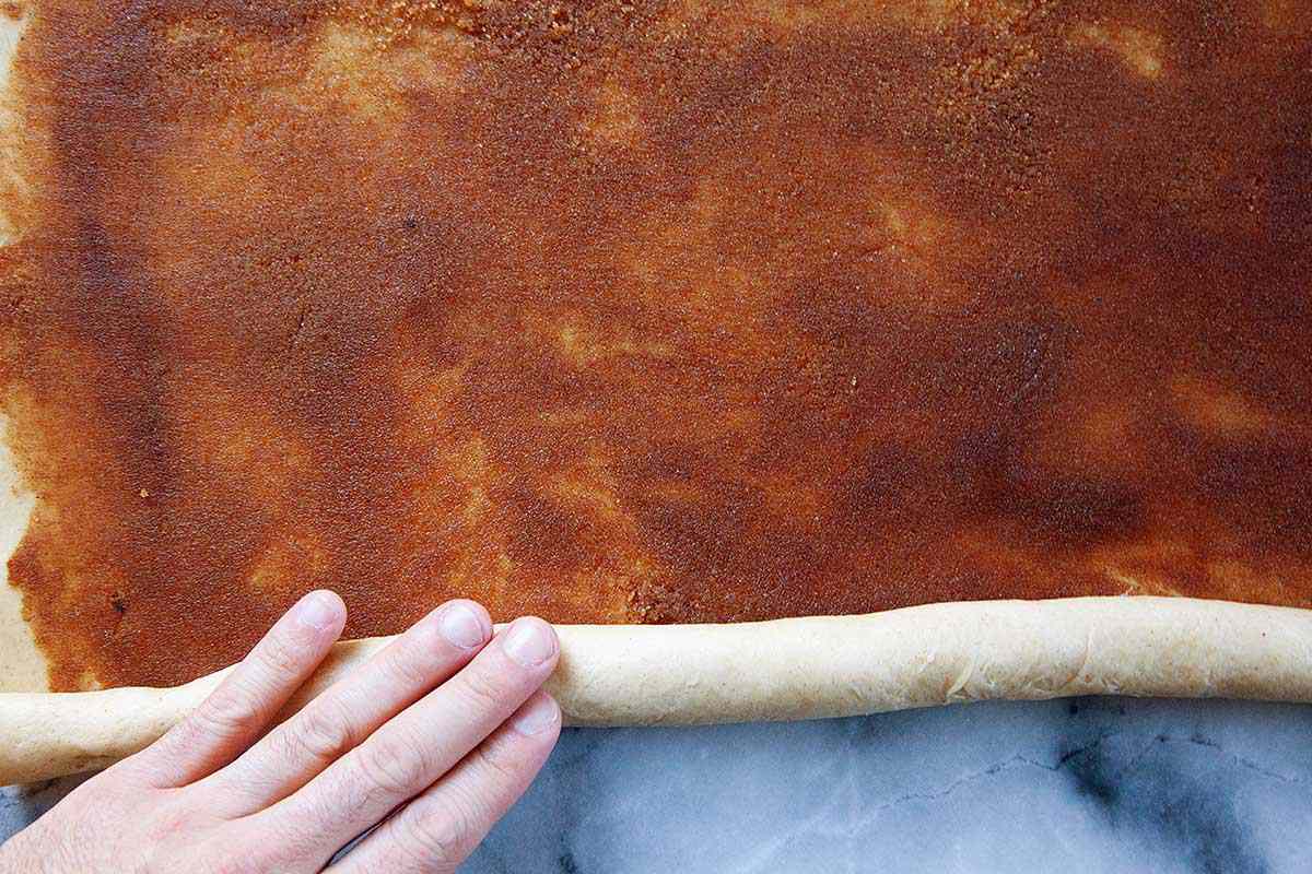 How to make a King Cake by rolling the dough up with the filling spread inside.