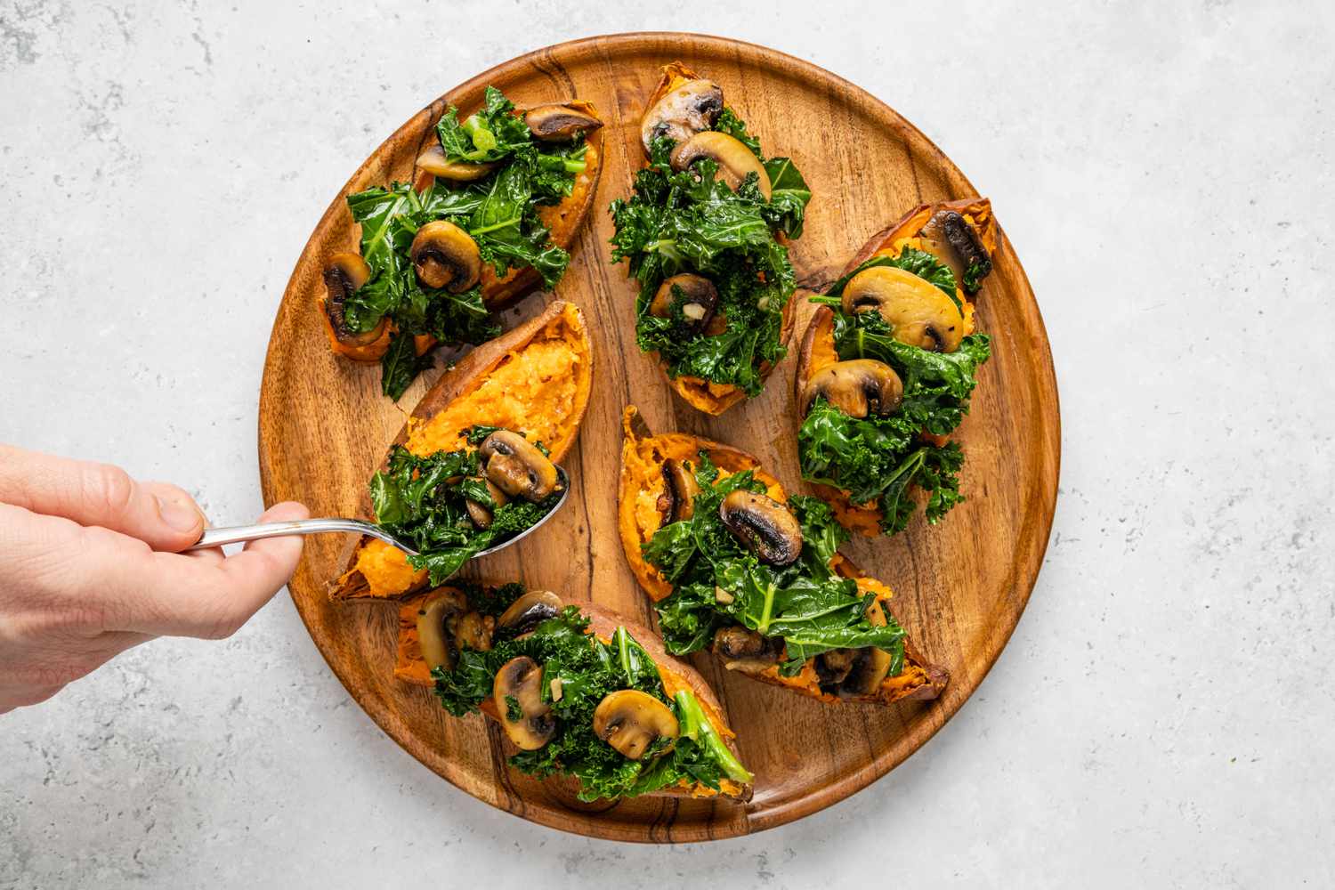 Top sweet potatoes with kale and mushrooms