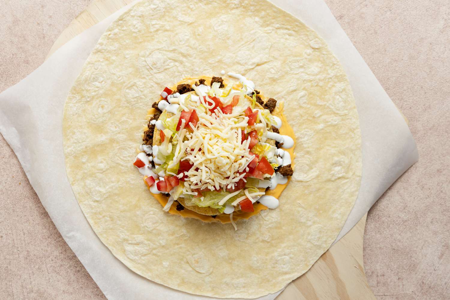 Lettuce, Tomatoes, Cheese, and Sour Cream Added to Homemade Crunchwrap Supreme 