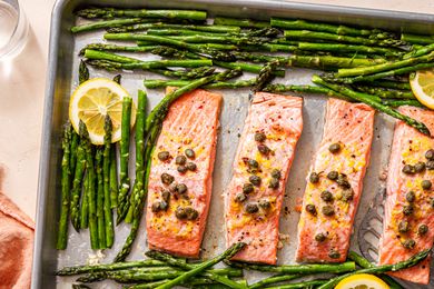 Overhead shot of baked salmon fillets and asparagus on a baking sheet