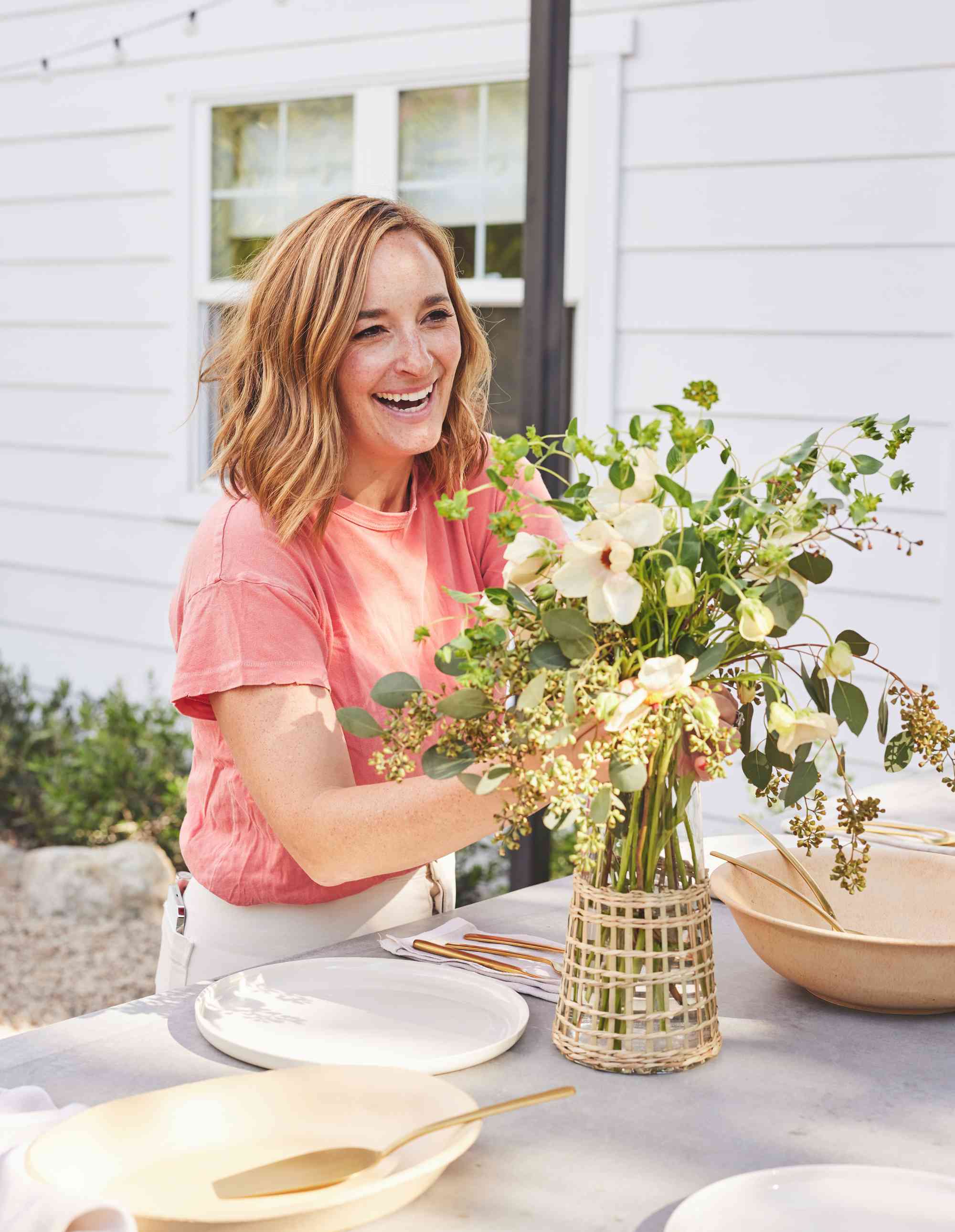 Gaby arranging flowers on her backyard dining table