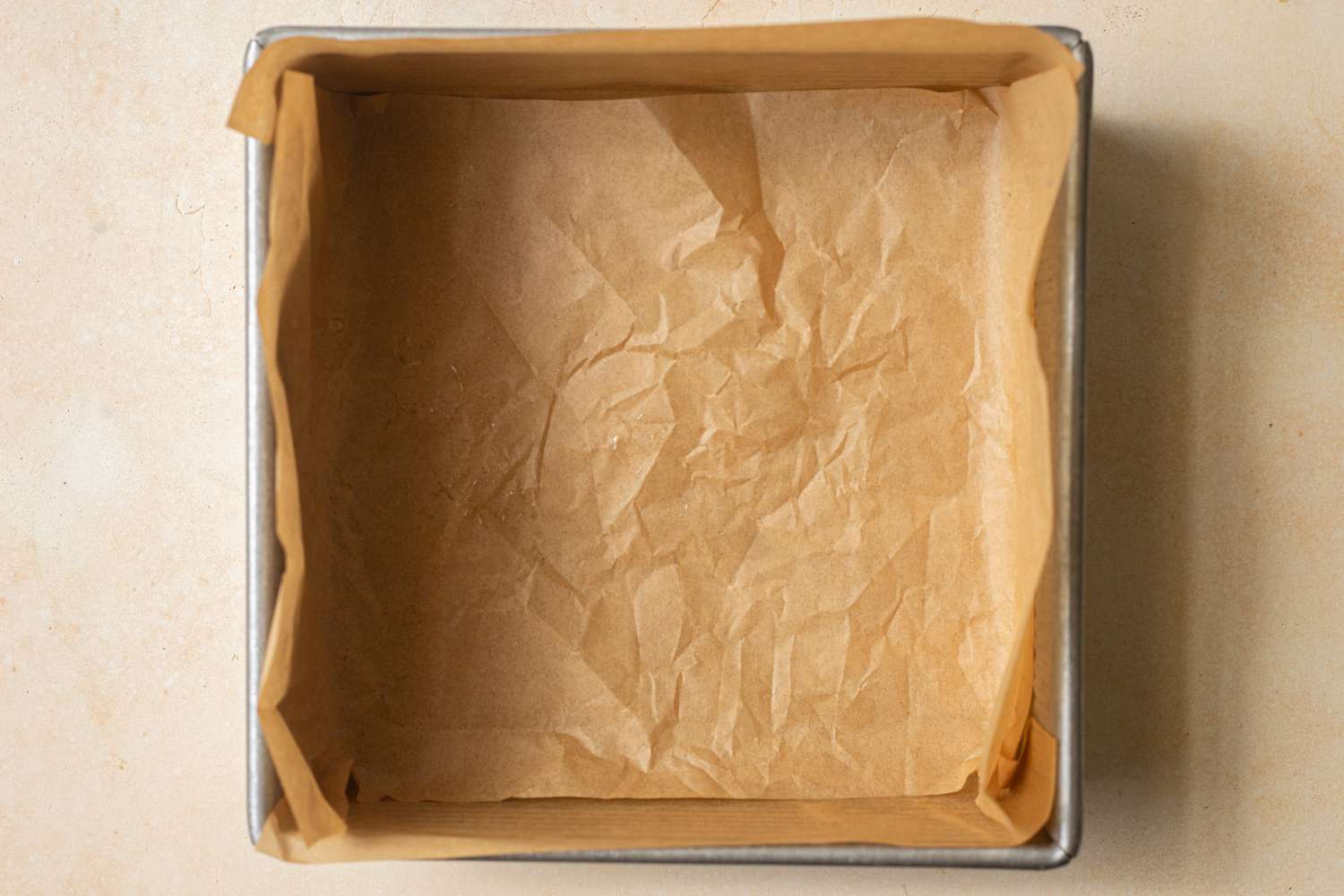 A baking pan covered in parchment paper to make pull apart rolls with garlic and parmesan.