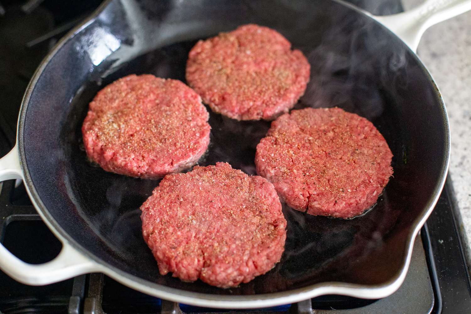 Burger Patties Cooking on a Cast Iron Skillet