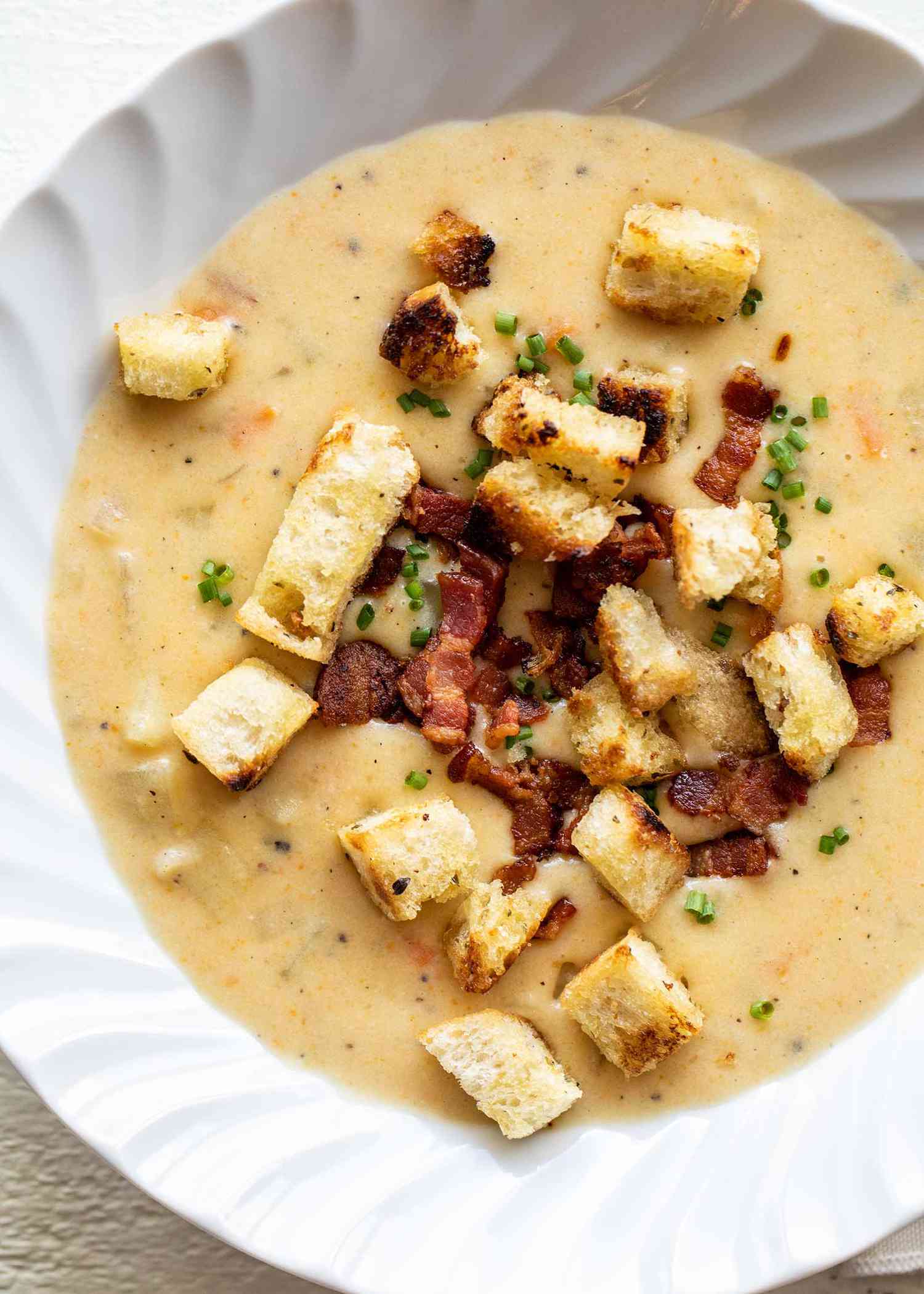Bowl of creamy easy potato soup with croutons and bacon bits