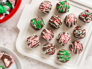 Plate of chocolate bonbons drizzled with frosting and decorated