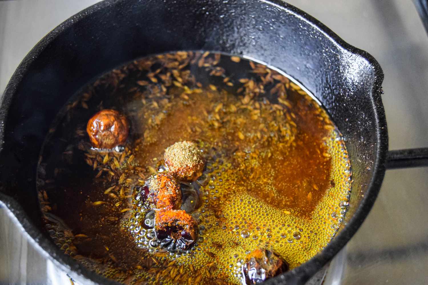 Kashmiri Chili Powder Added to Hot Tadka Mix in the Small Cast Iron Skillet for Daal Palak