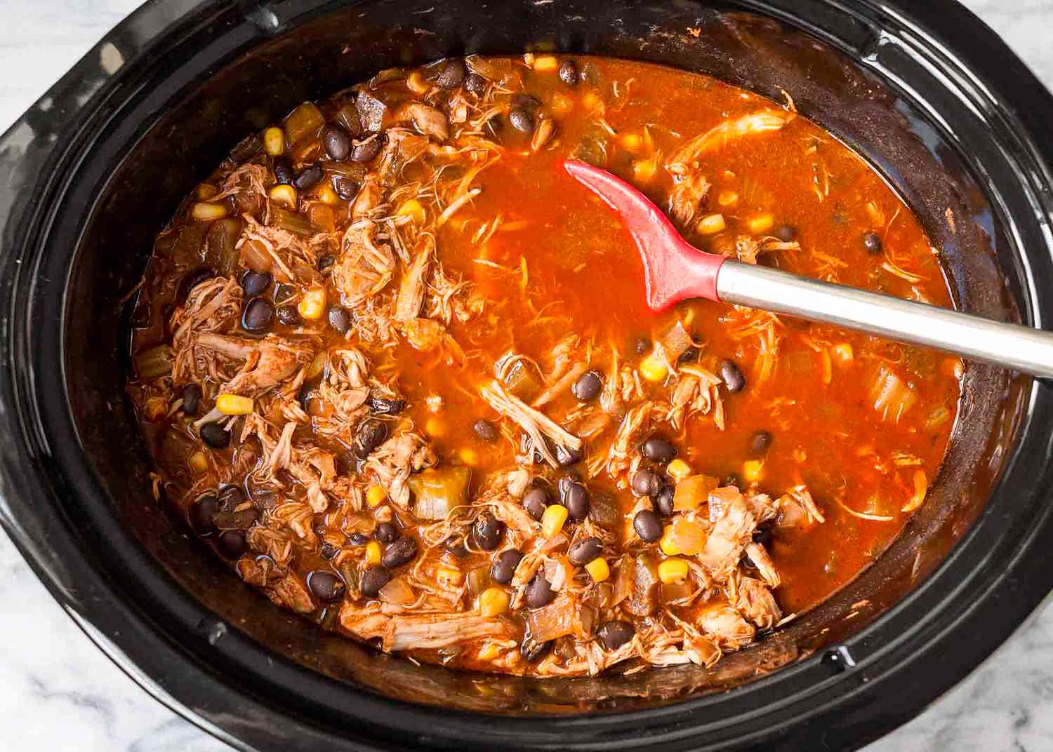 Overhead view of a slow cooker with chicken chili