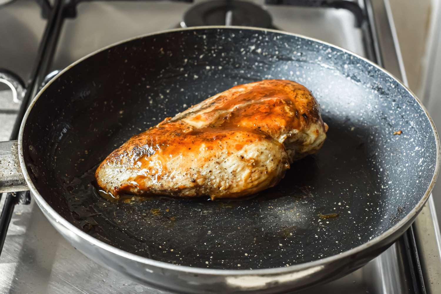 Chicken Breast Cooking in a Skillet on a Gas Range for Chicken Alfredo Pizza Recipe