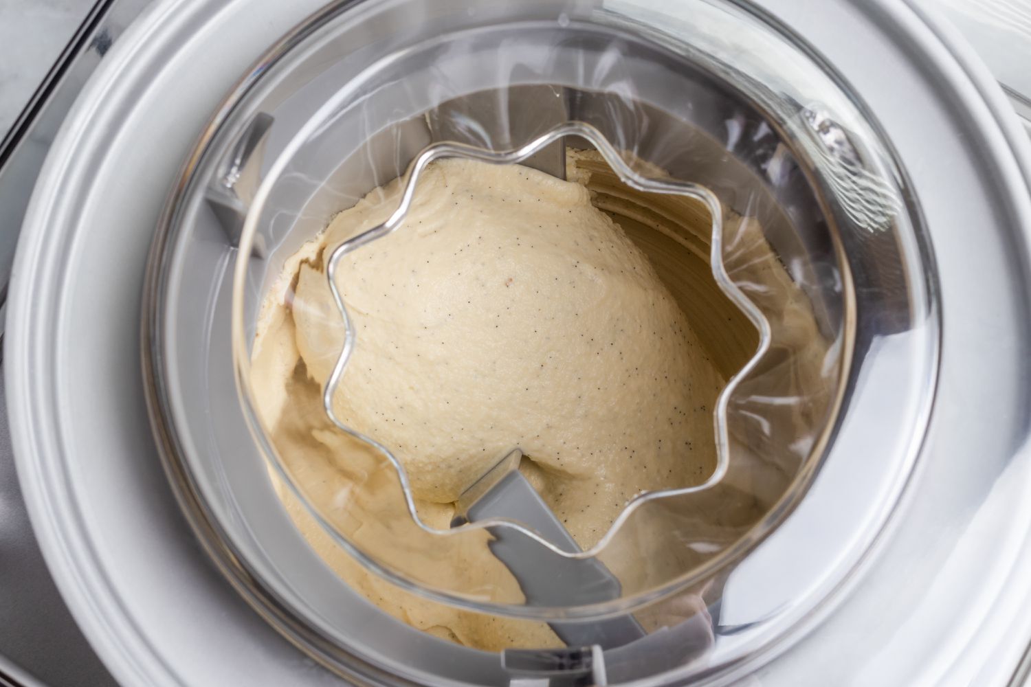 Processing the custard in an ice cream maker to make a vanilla ice cream recipe.