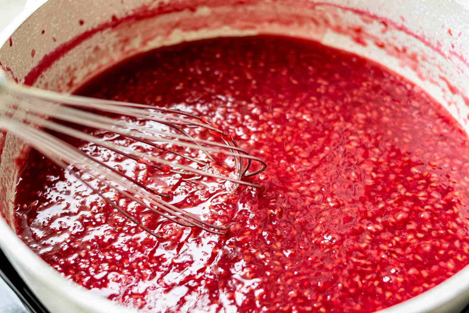 Whisking the raspberry sauce in a pot