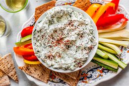 Bowl of Easy Spinach Dip Surrounded by Veggie Strips and Pita Triangles