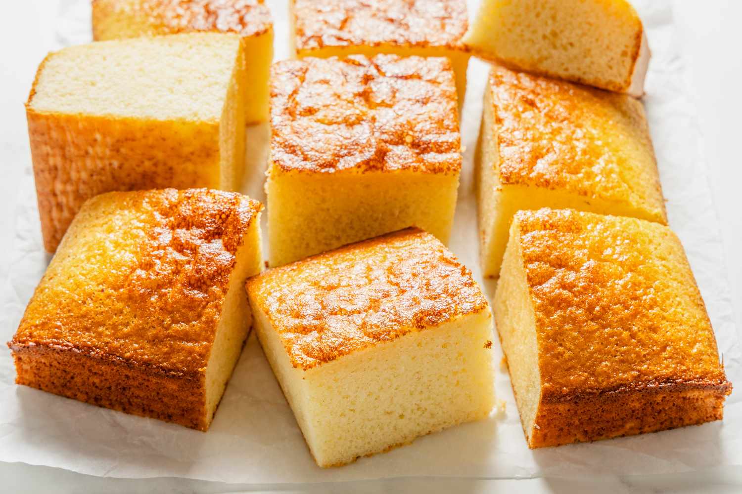 Pieces of condensed milk cake arranged on white paper