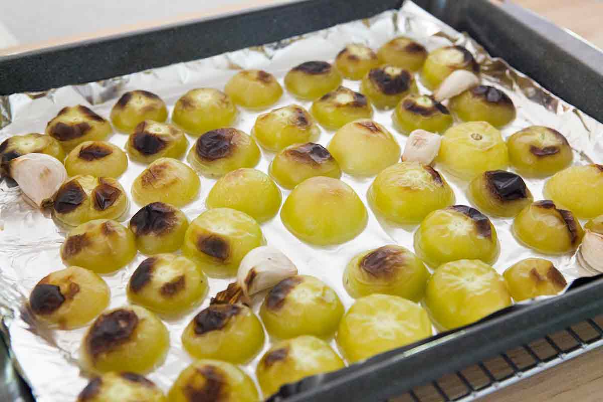 Tomatillos on a baking sheet that have been roasted 
