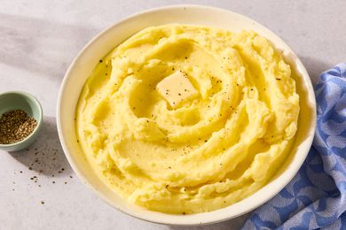 A bowl of creamy mashed potatoes with a butter pat on top