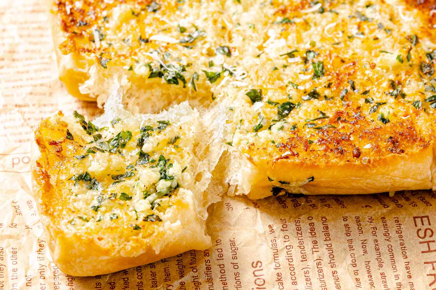 A very cheesy and golden brown garlic bread showing a piece being pulled away.