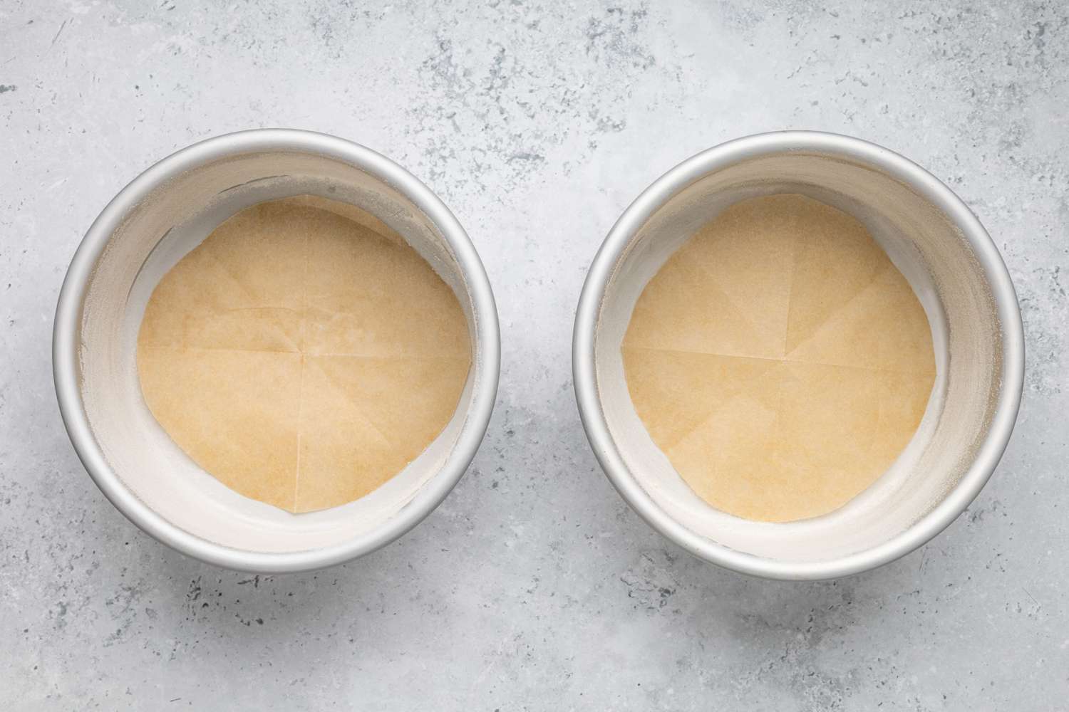 Two Circular Baking Pans Lined with Parchment Paper for One-Bowl Double-Layer Chocolate Cake Recipe