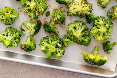 Broccoli florets on a sheet pan ready to be roasted with spices, bread crumbs and olive oil