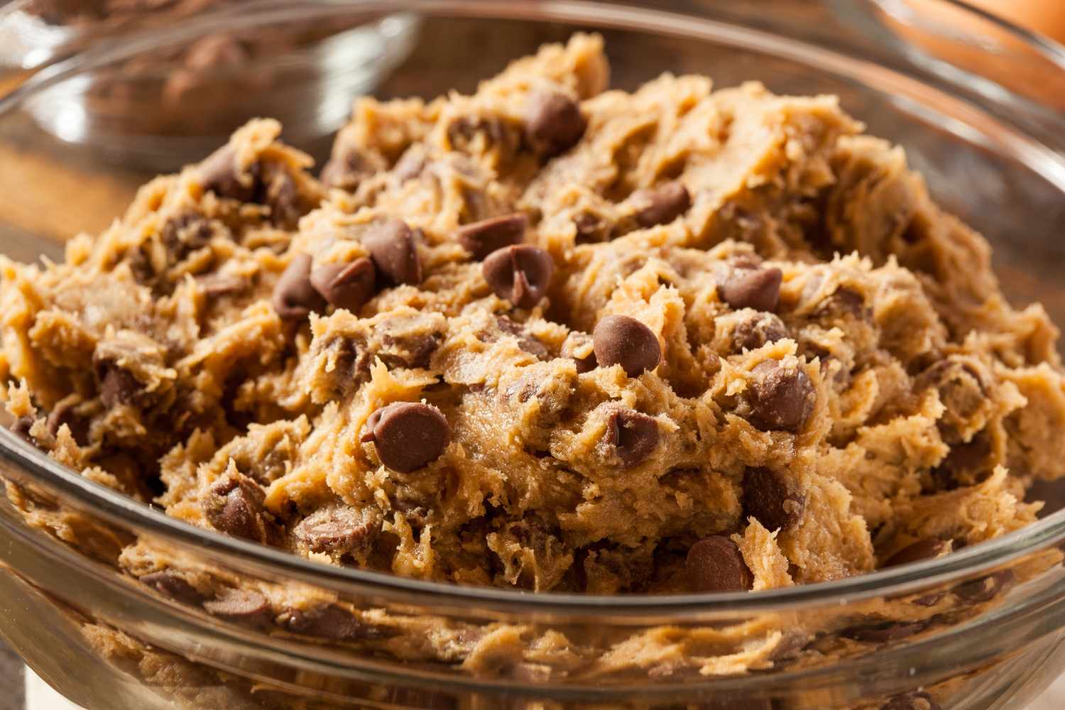 Cookie dough with chocolate chips in a clear glass bowl