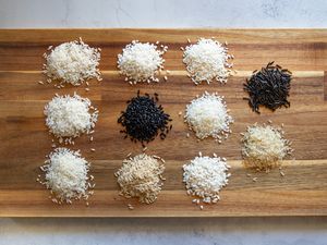 Piles of rice varieties on a wood chopping board