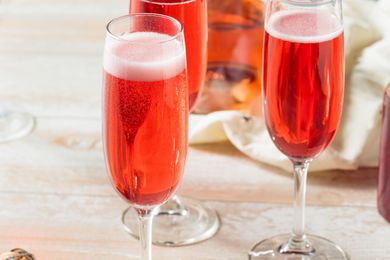 a red bubbly cocktail in a champagne glass