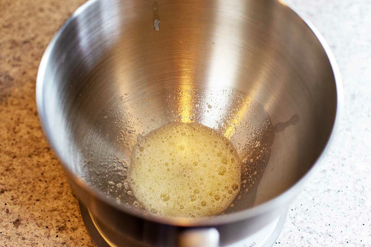 Egg whites at the bottom of a metal stand mixer bowl to make Hungarian Nut Horns.