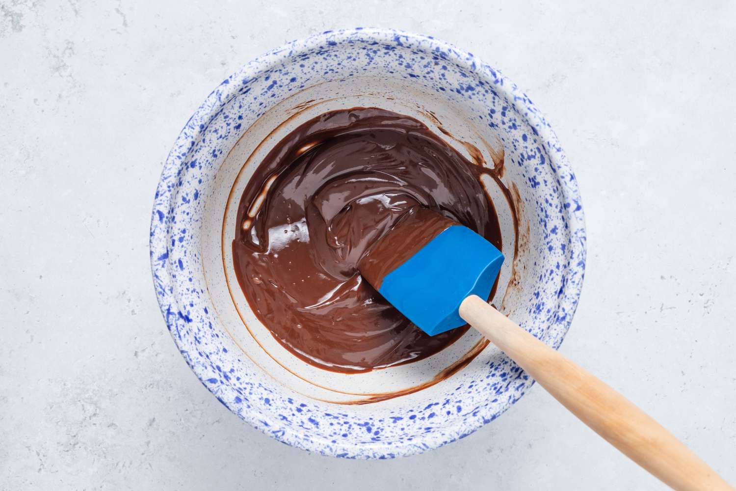 Bowl of ganache with a rubber spatula for homemade Cosmic Brownie ganache