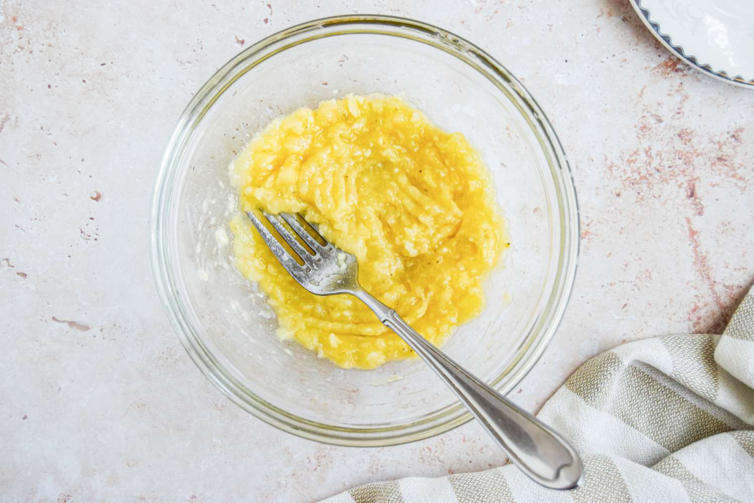Bananas Mashed in a Bowl Using a Fork for Banana Bread Chocolate Chunk Mug Cake Recipe
