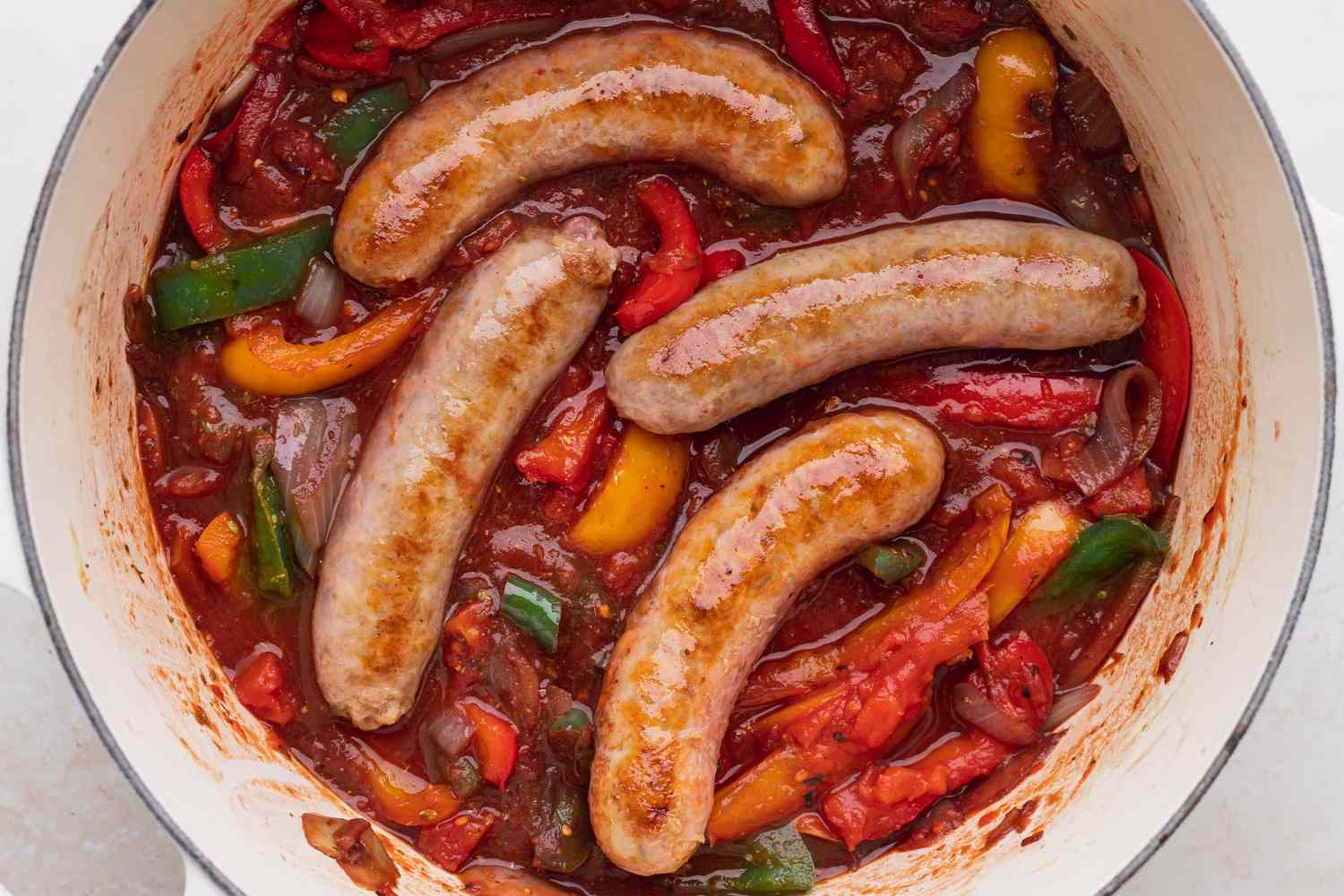 A pot of cooked Italian sausage, peppers, and onions