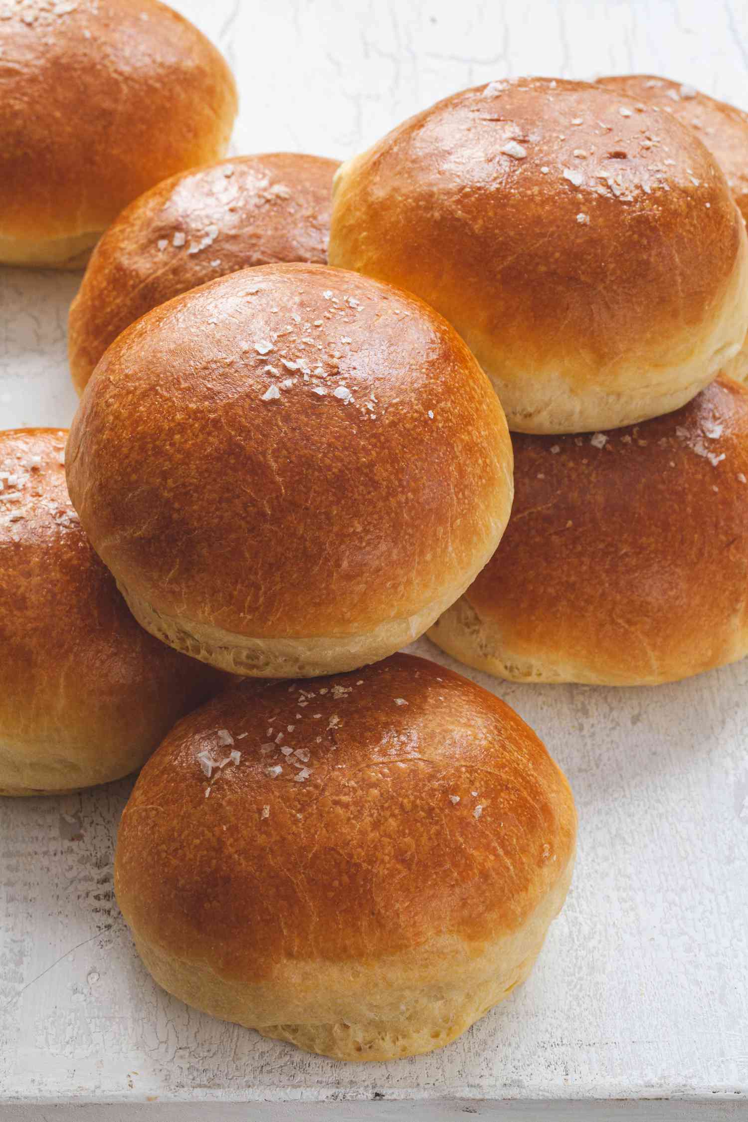 The Fluffiest Brioche Buns stacked on a counter.