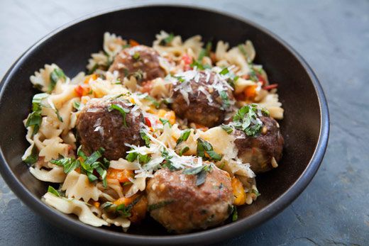 Turkey meatballs with tomato and basil served with pasta and cheese in a bowl
