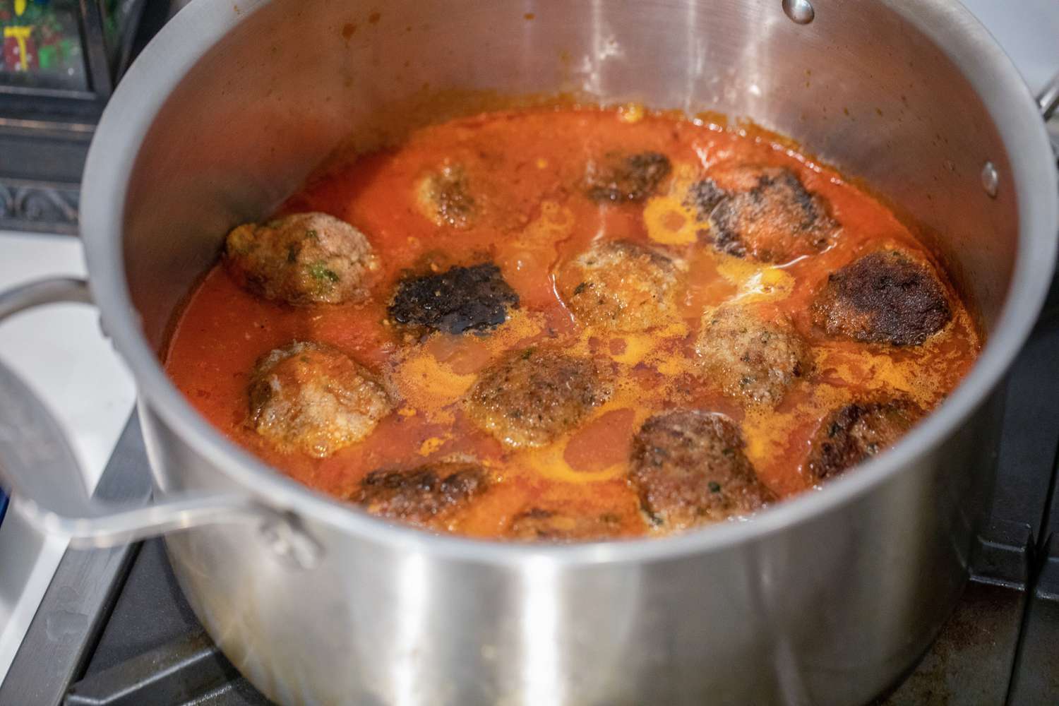 Meatballs Cooking in a Pot of Marinara Sauce for Gameday Meatball Sub Recipe 