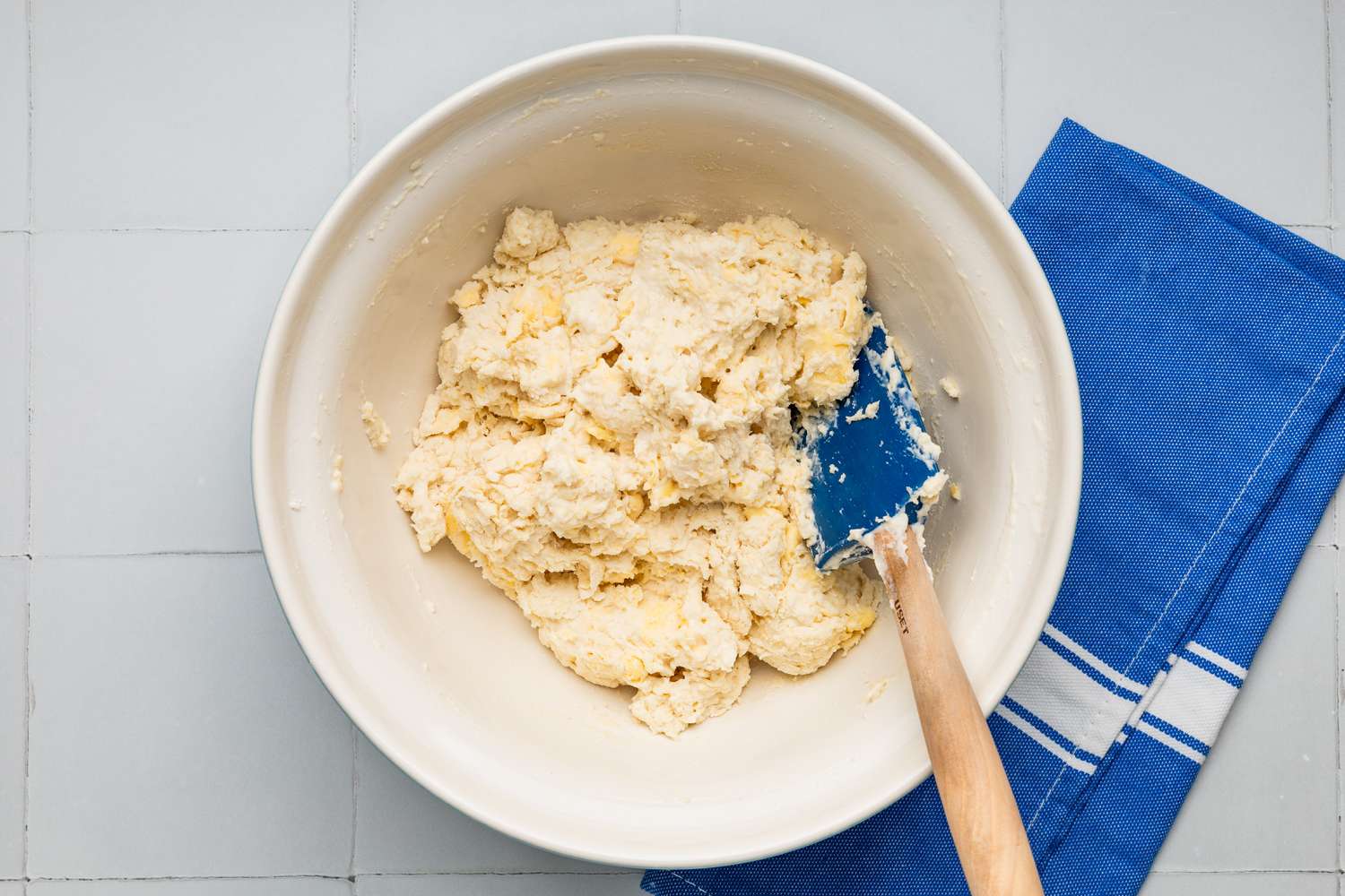 Drop biscuit dough in a bowl with a spatula 