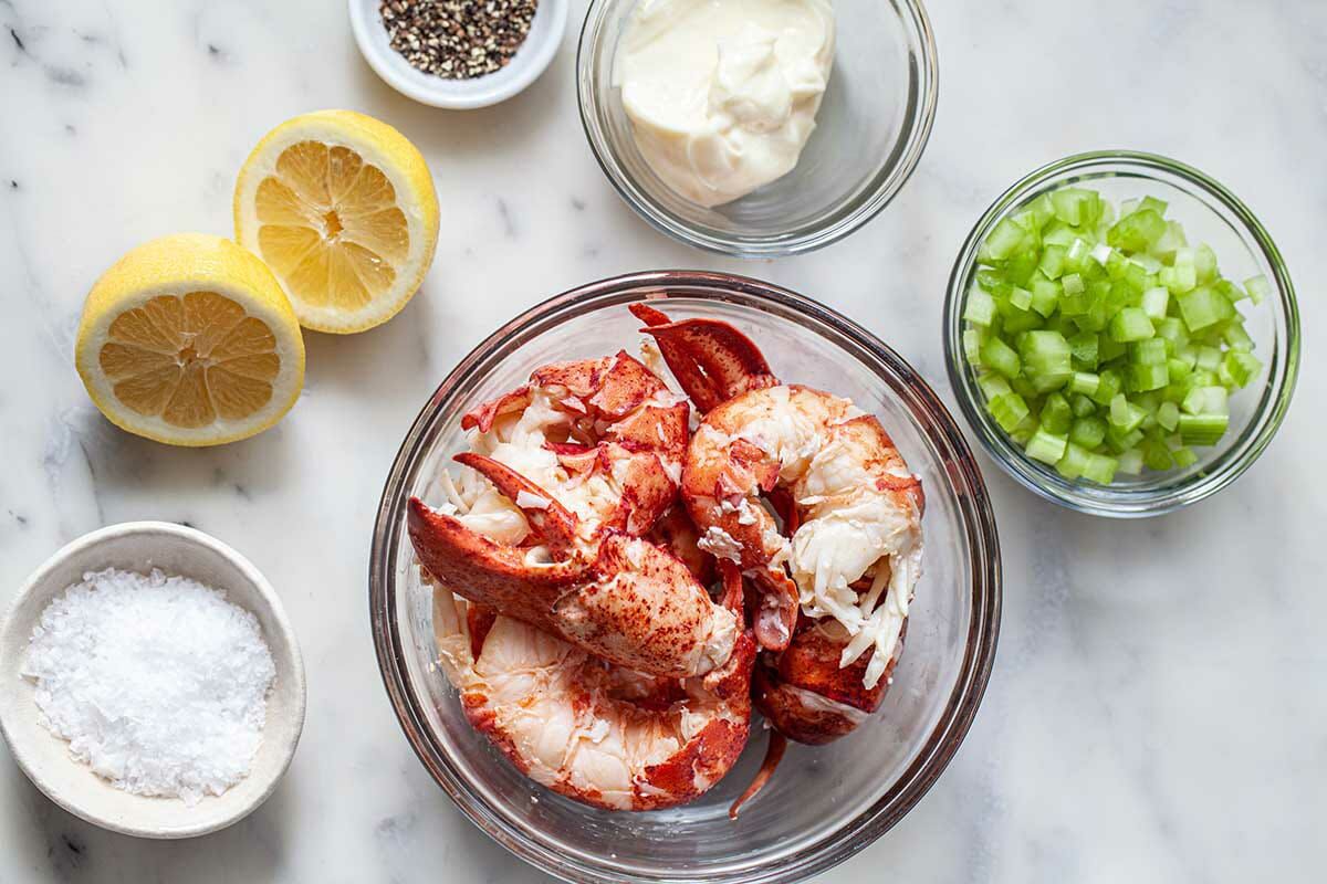 How to make lobster rolls with individual bowls of the lobster salad ingredients set on a table.