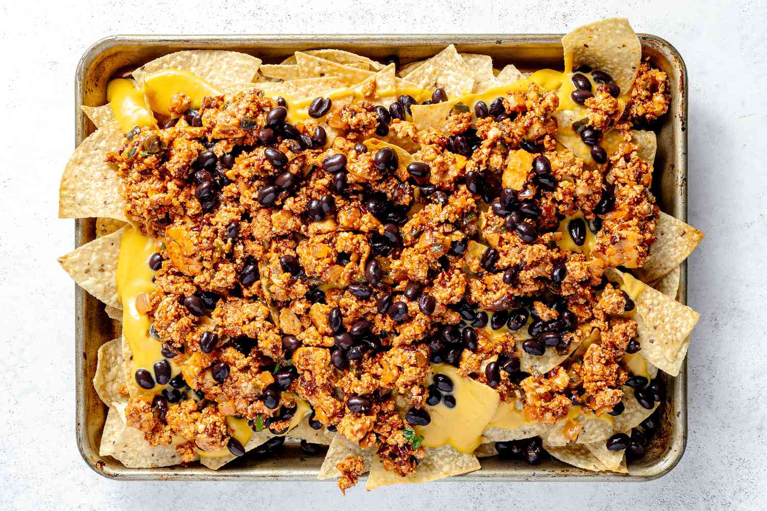 Tortilla Chips Topped with Vegan Queso, Copycat Sofritas, and Black Beans for Nachos Vegan Recipe