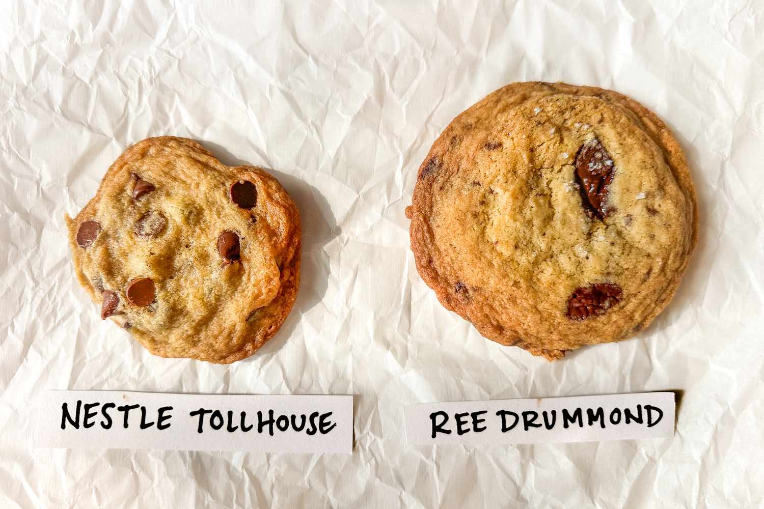 Two cookies labeled as Nestle Tollhouse and Ree Drummond placed side by side on a white surface