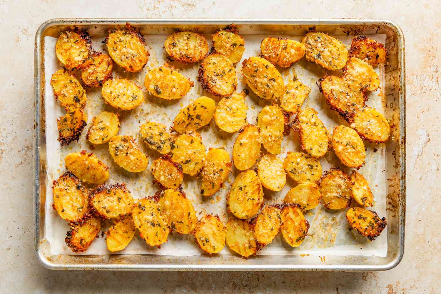 crispy parmesan potatoes on a baking sheet (crispy side up)