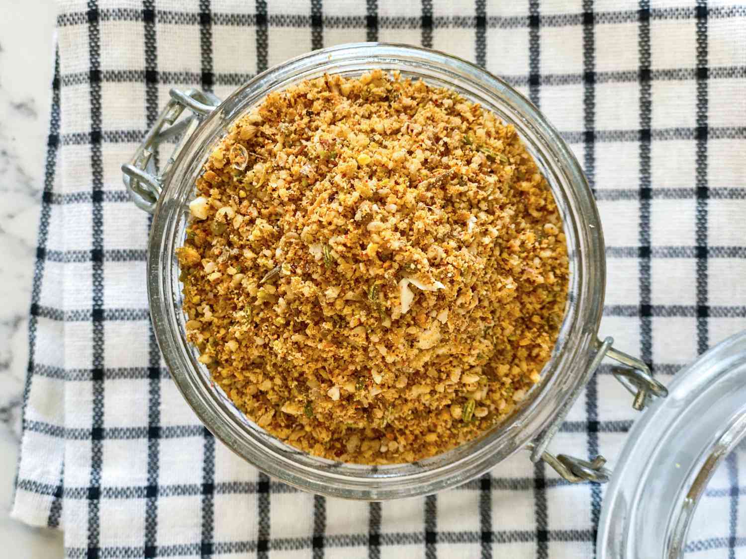 Overhead view of Dukkah spice blend in a glass container.