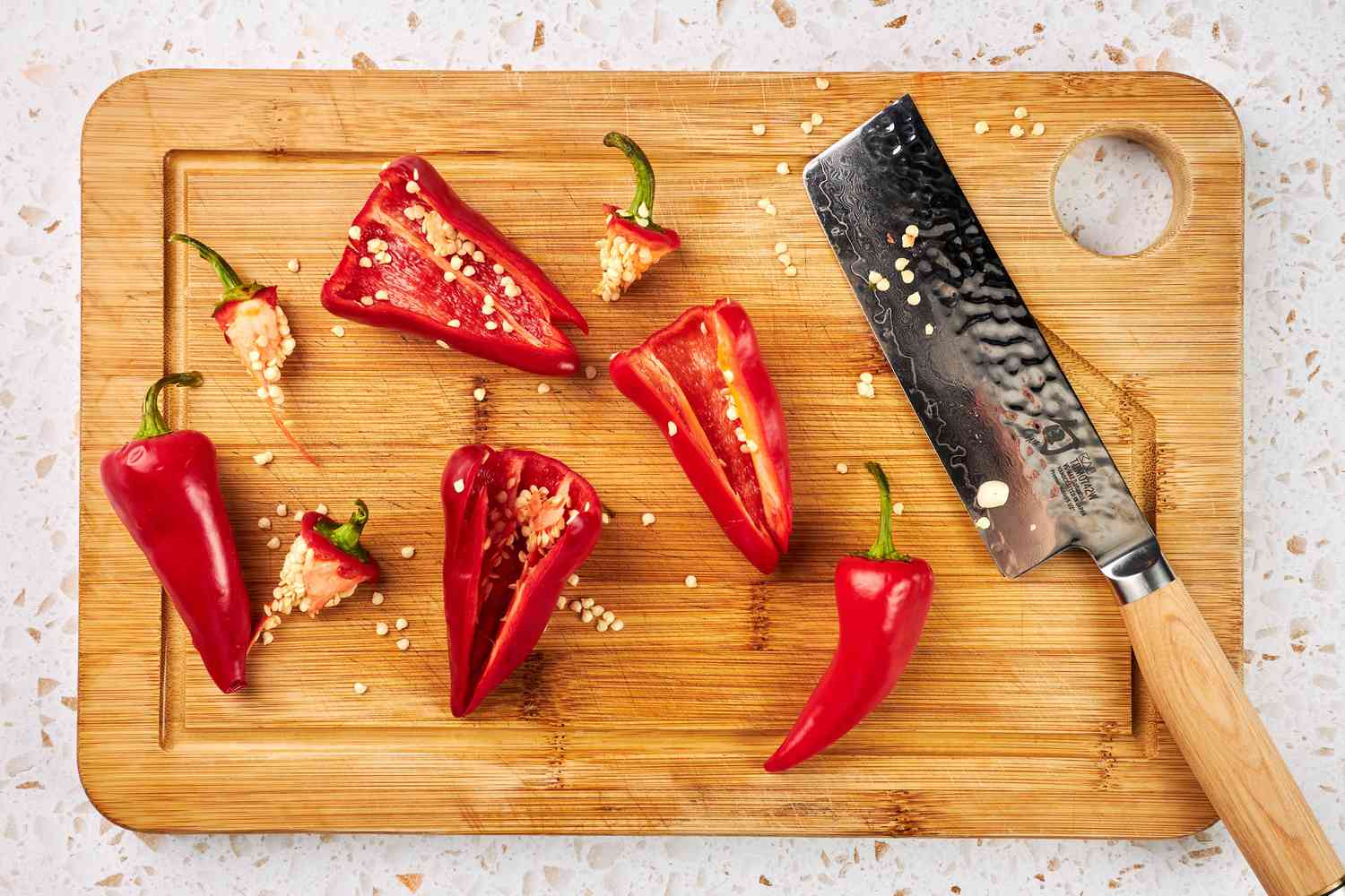 Red Fresno peppers on a cutting board, sliced open
