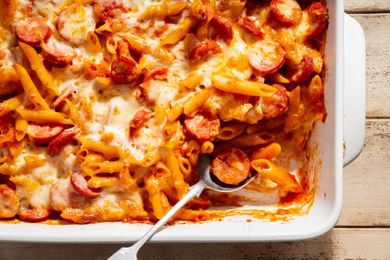 Penne and Smoked Sausage Casserole in a baking dish with a serving spoon