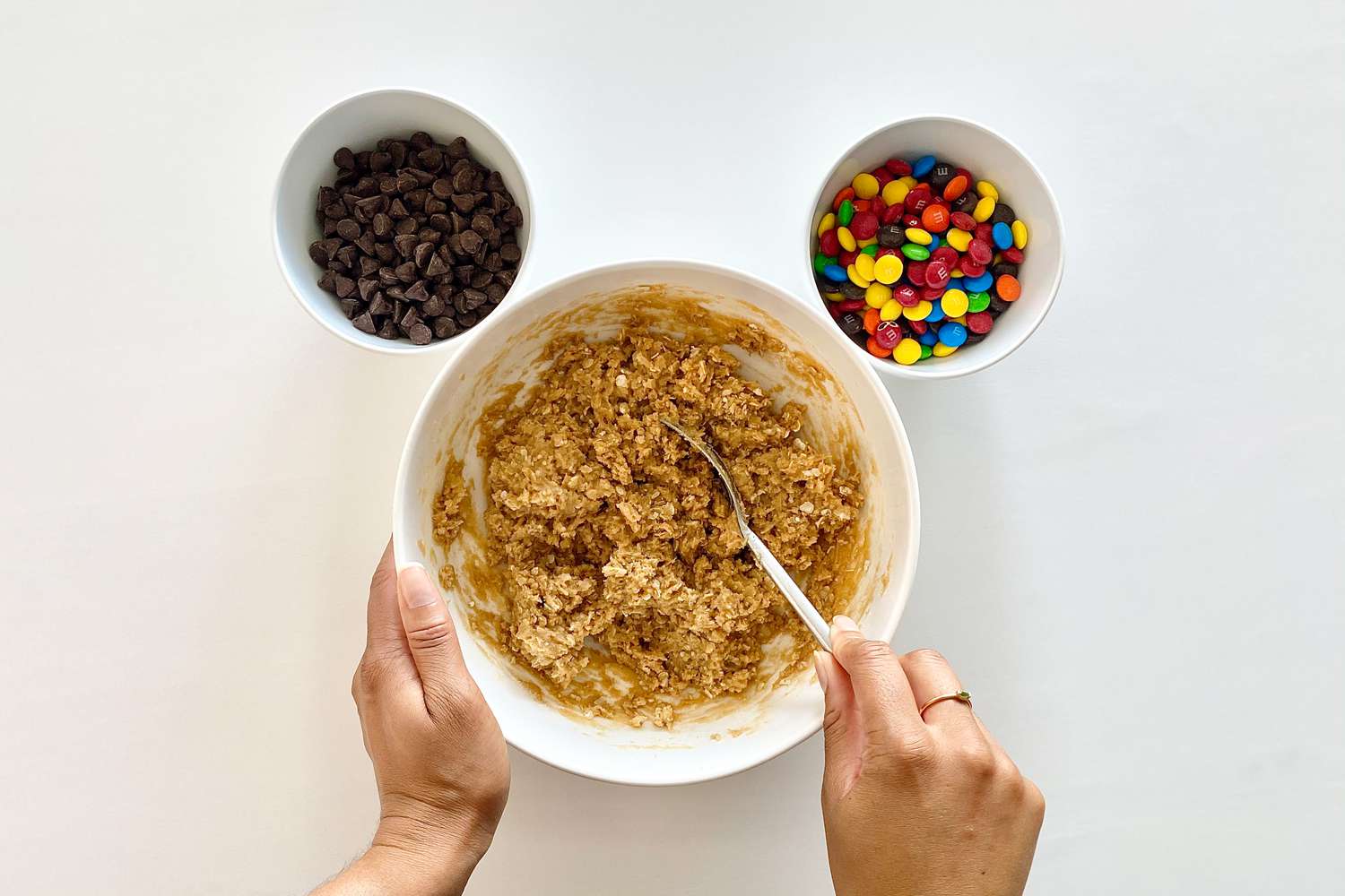 Adding flour mixture to wet mixture to make Gluten-Free Sheet Pan Monster Cookies.