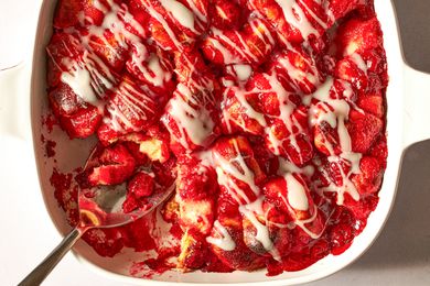 Closeup overhead shot of cherry cobbler in a baking dish, drizzled with a glaze