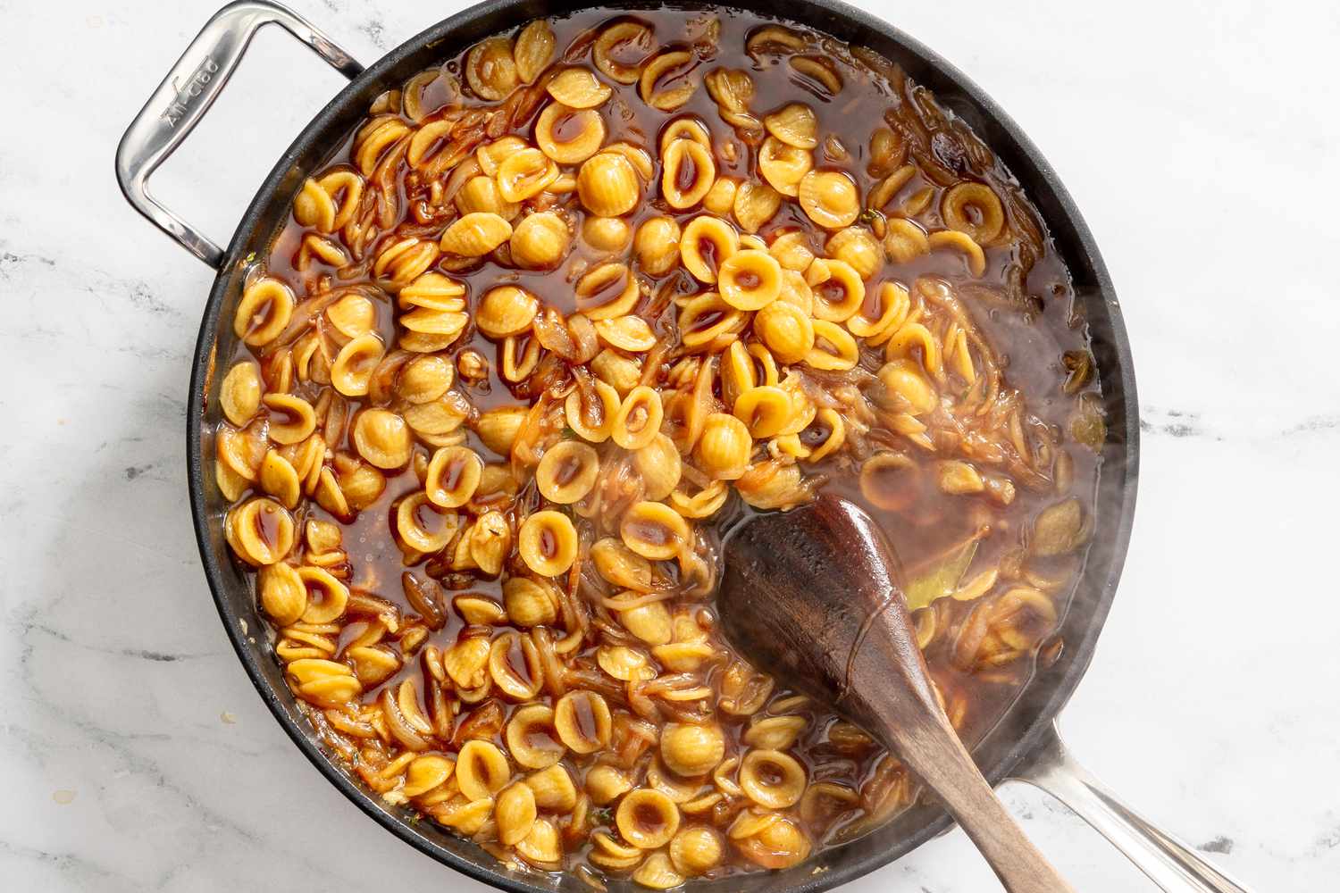 pasta stirred while cooking in a pot for French onion pasta recipe