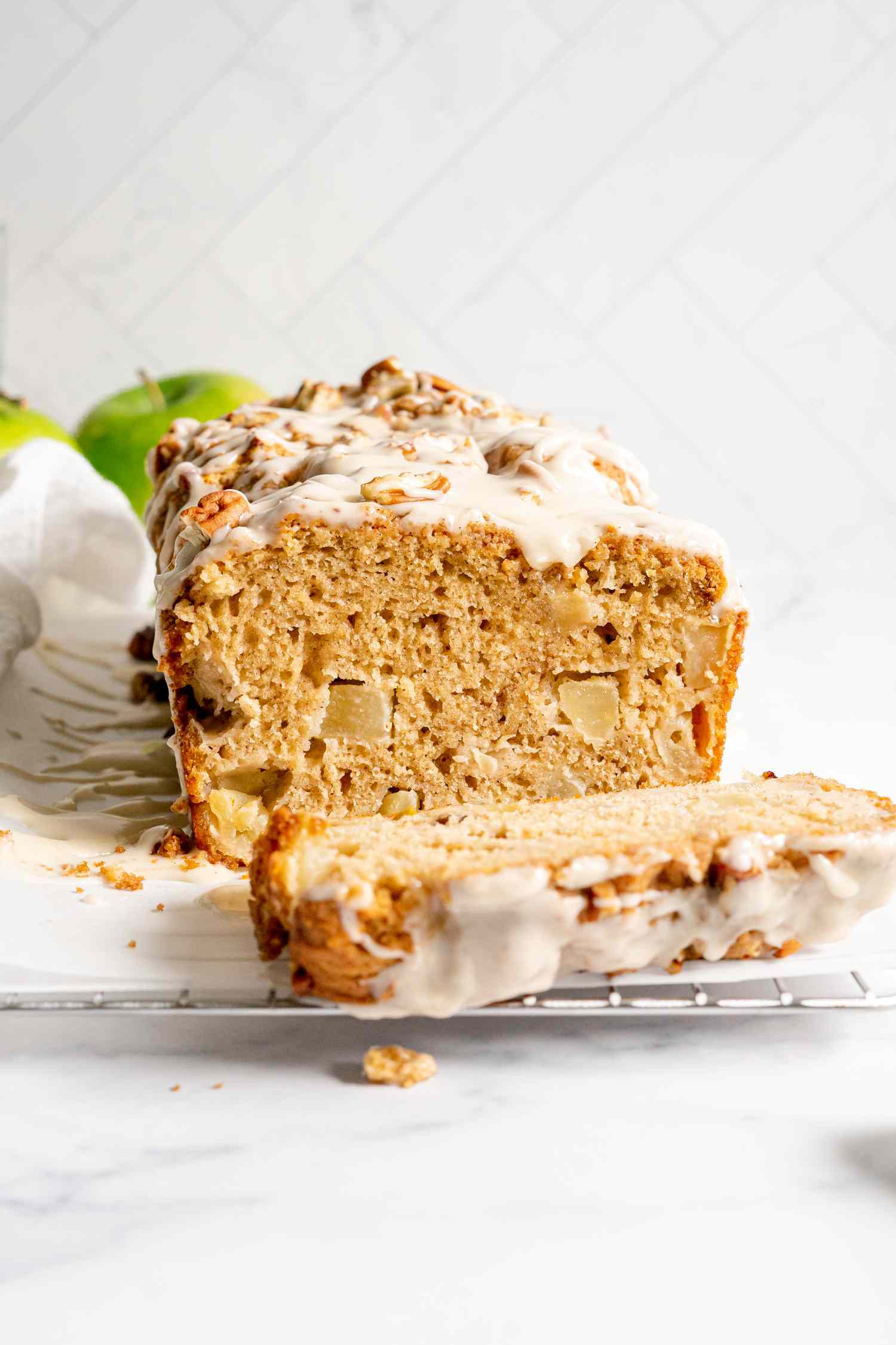 Apple Fritter Bread with a Slice Cut Off on Parchment Paper