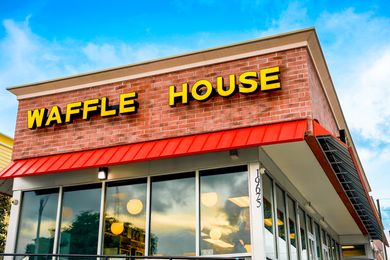 The exterior of a Waffle House restaurant building showing the sign with the name and large windows