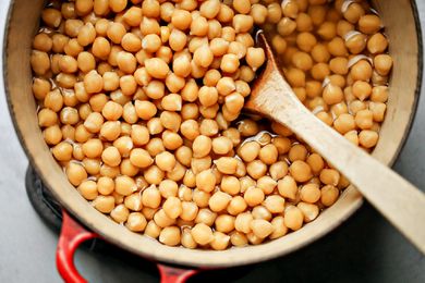 How to Cook Dry Beans - chickpeas in a Dutch oven with a wooden spoon