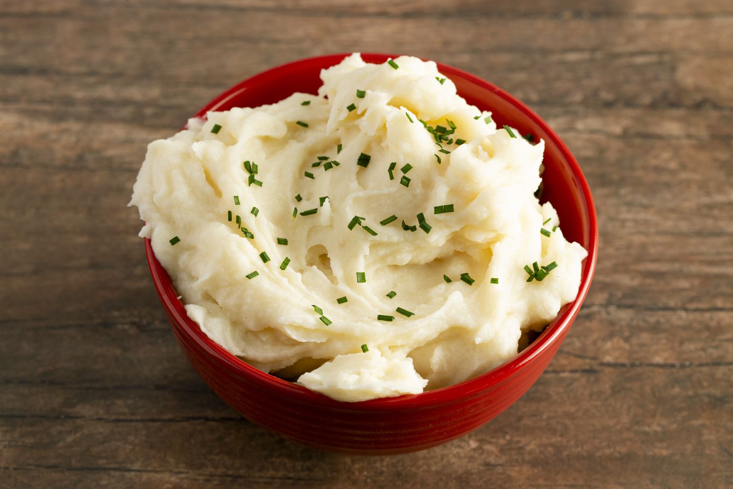 A bowl of creamy mashed potatoes topped with chives