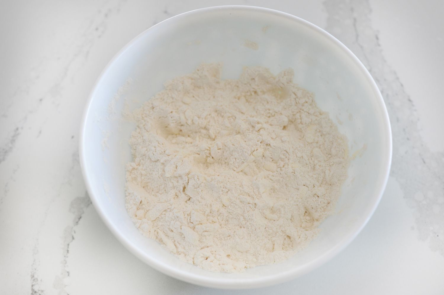 Butter and dry ingredients mixed in a bowl to show How to Make English Scones.
