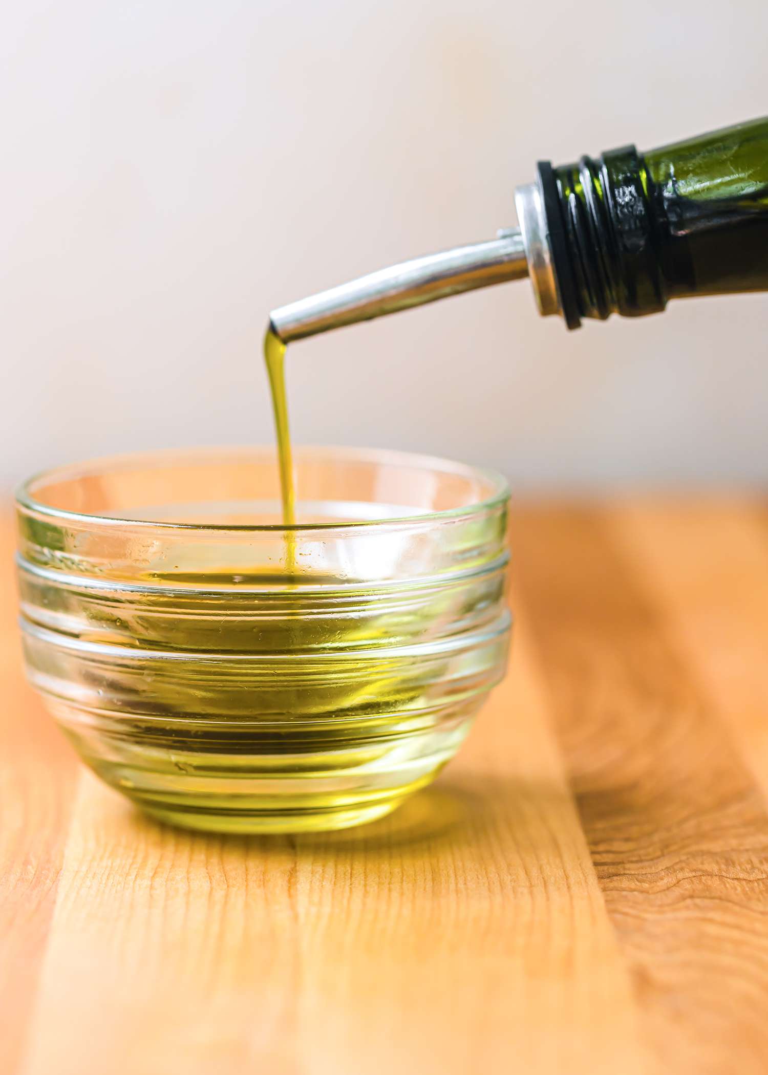 Pouring avocado oil into a glass bowl