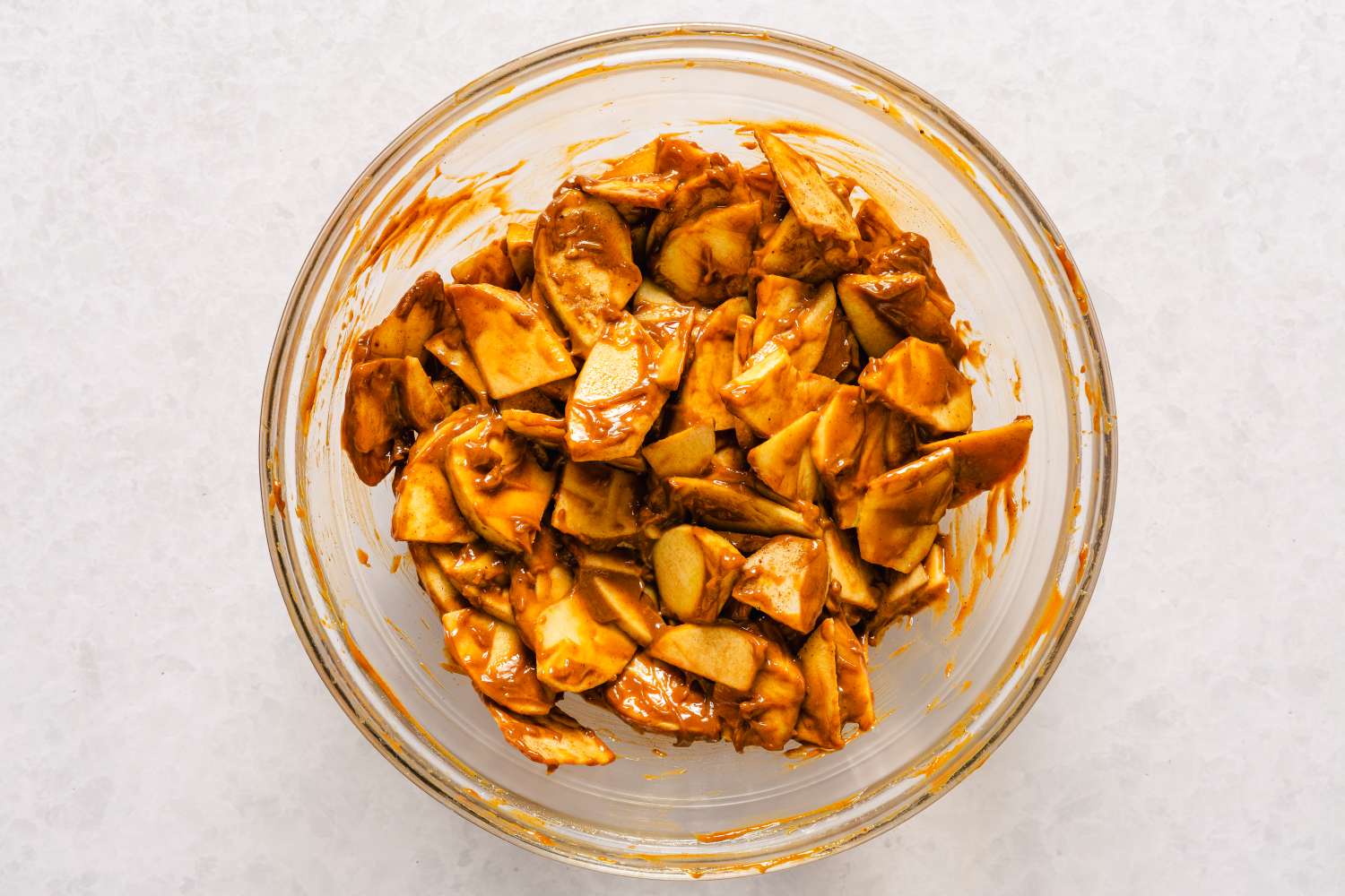Glass bowl filled with caramelcoated apple slices for caramel apple bars recipe
