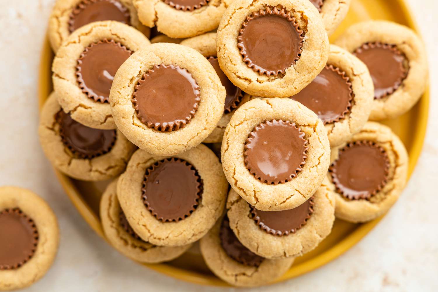 Stack pf Peanut Butter Cup Cookies on a Plate with One on the Counter